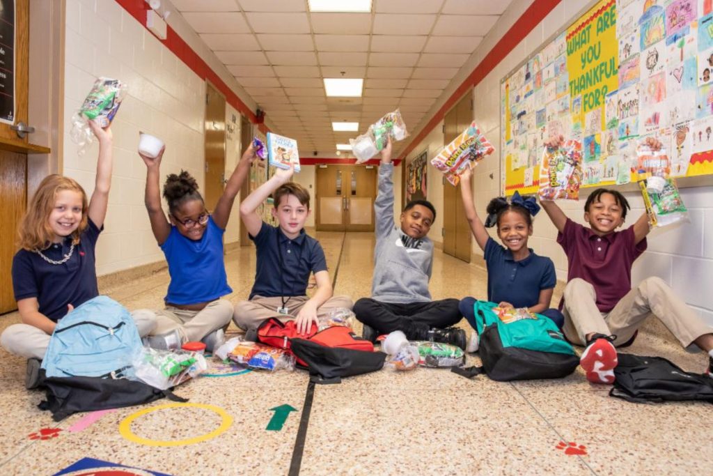 Kids holding food above their heads with excitement